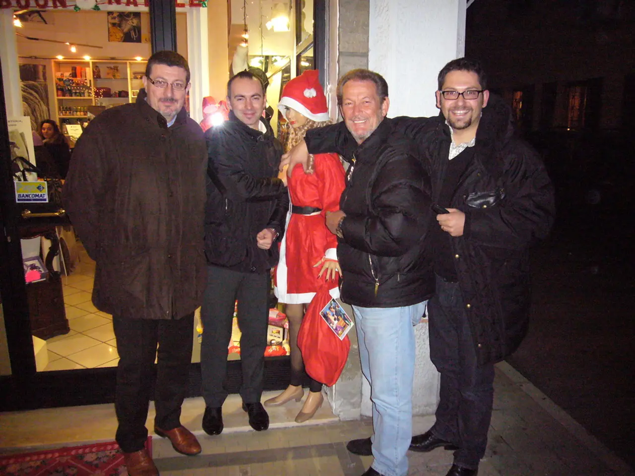 In this image we can see persons standing on the floor and some are sitting on the chairs. In the...