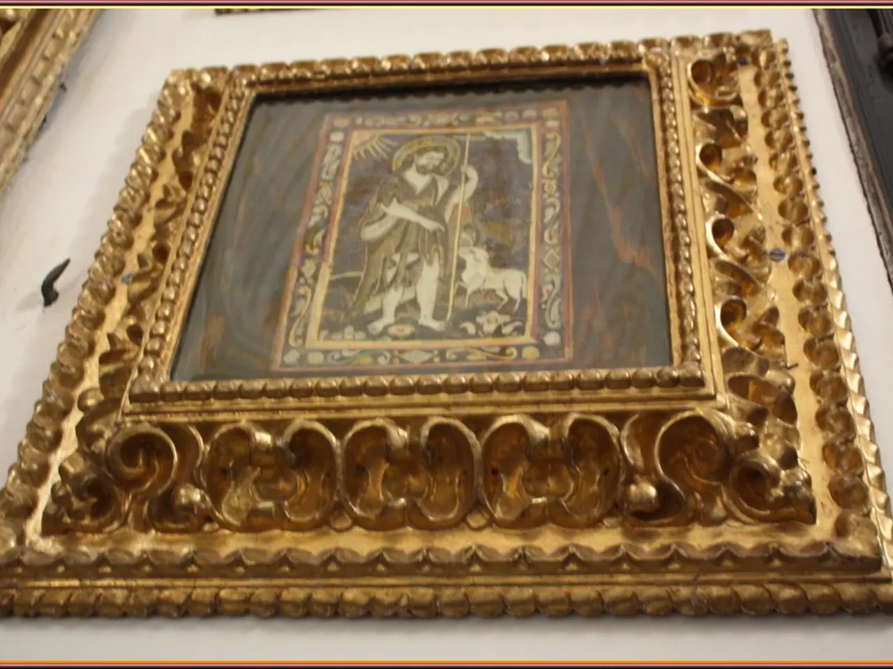 Here in this picture there is a gold frame hanging on the wall.