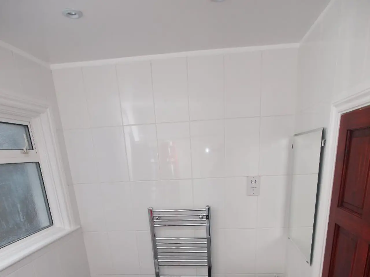 In this image I can see the black colored floor, a toilet seat, a flush tank, two sinks, the white...