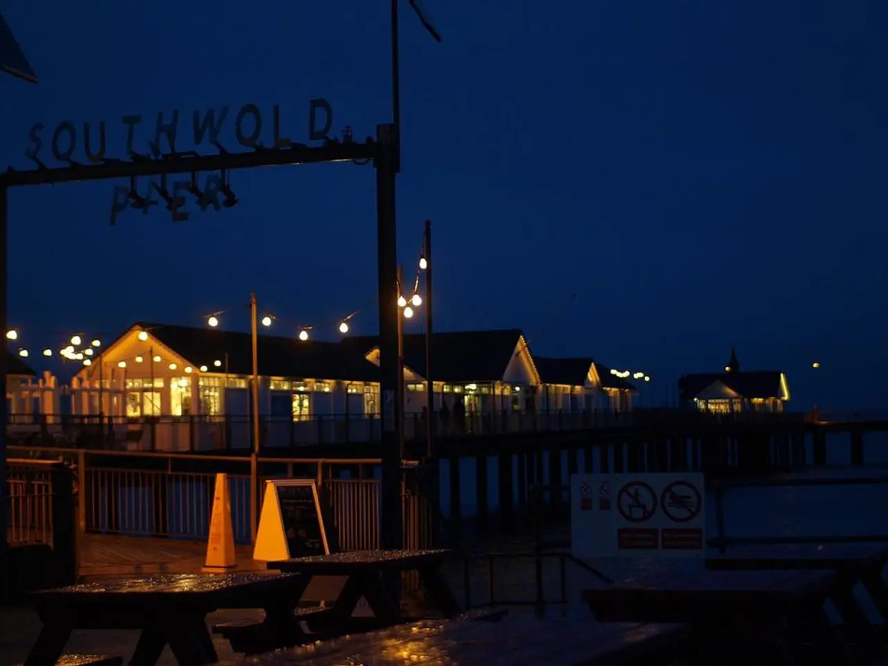 Here we can see houses,fence,wooden poles,decorative lights,some objects on the floor,sign board on...