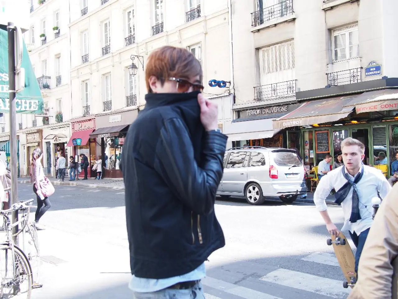 In this image we can see a person wearing specs. On the right side there is a person holding a...