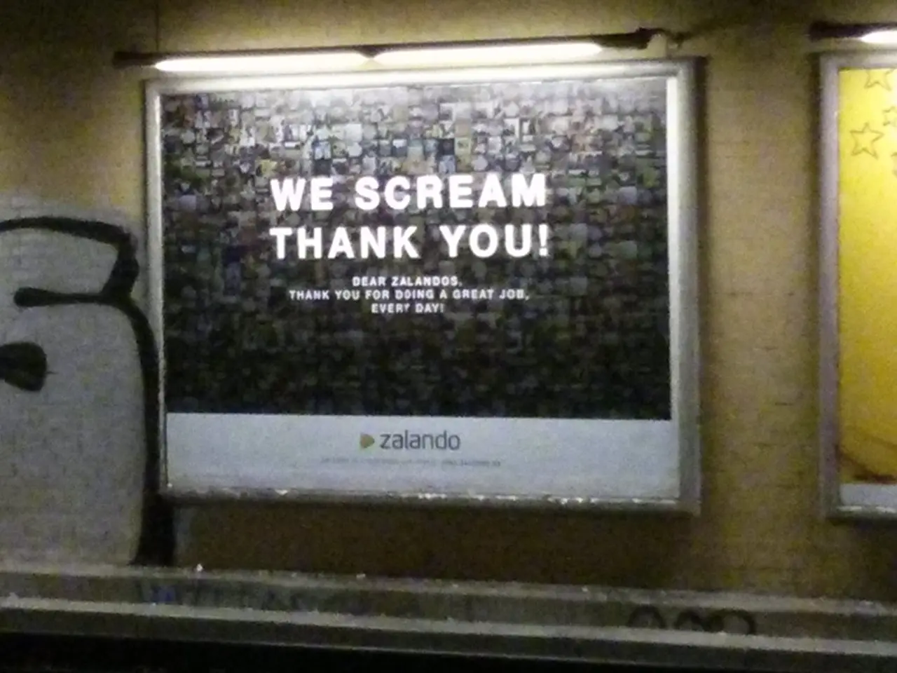 Hoardings are on the wall. Above this hoardings there are lights.