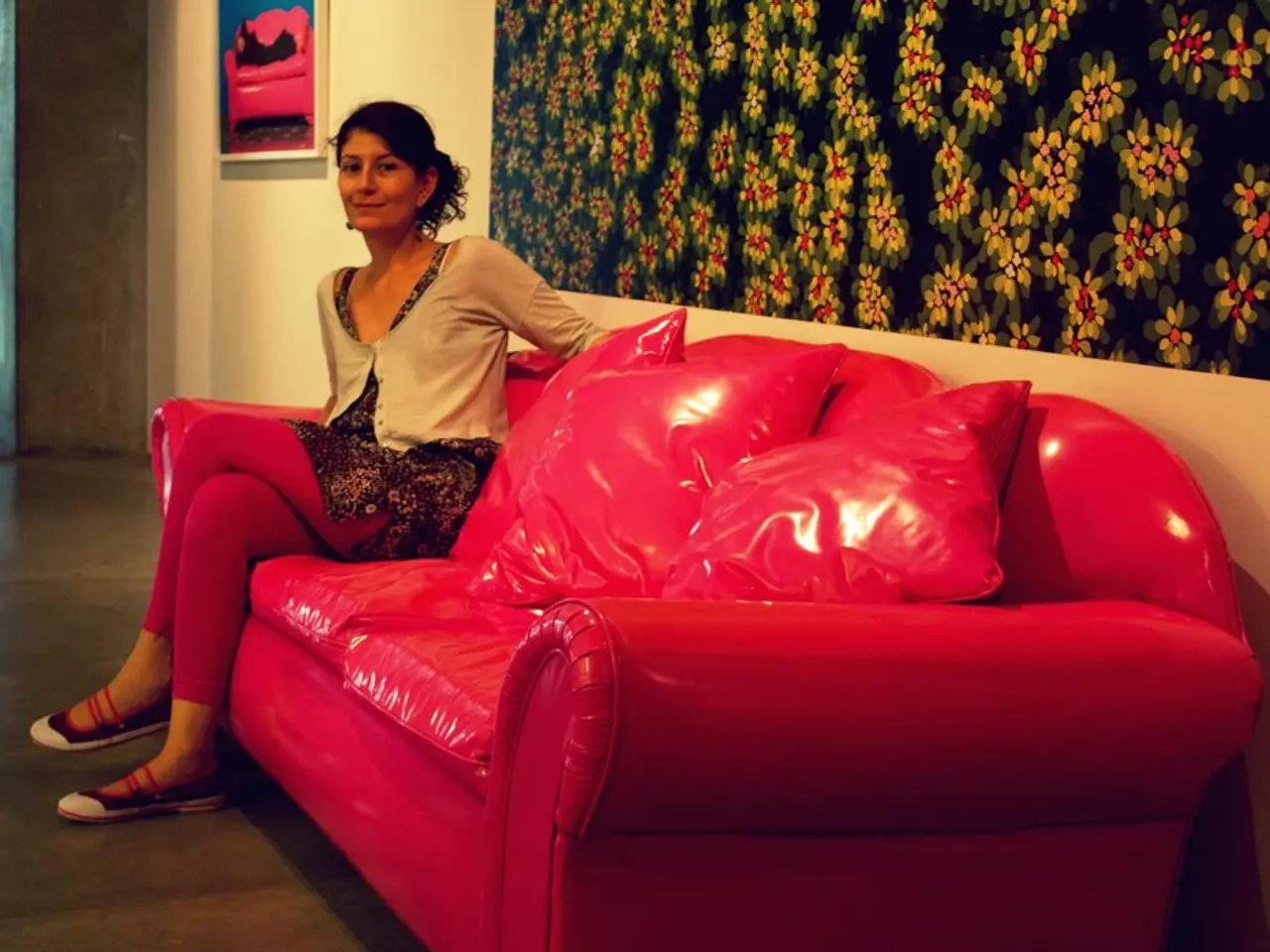 Here we can see a woman sitting on a couch and there are cushions on it, behind her we can see...
