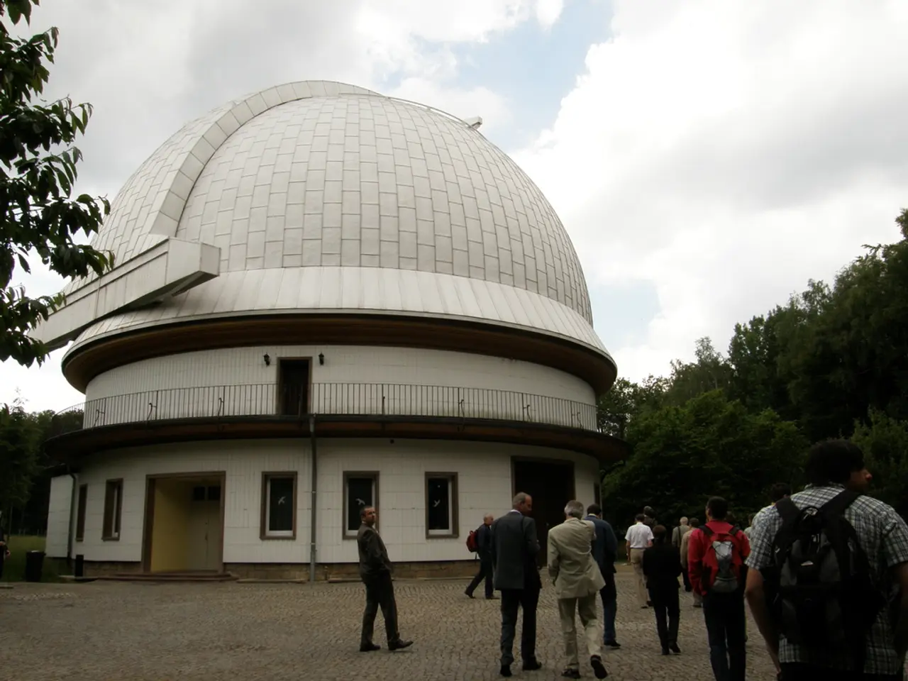In this image we can see people walking on the floor and some of them are wearing backpacks. In the...