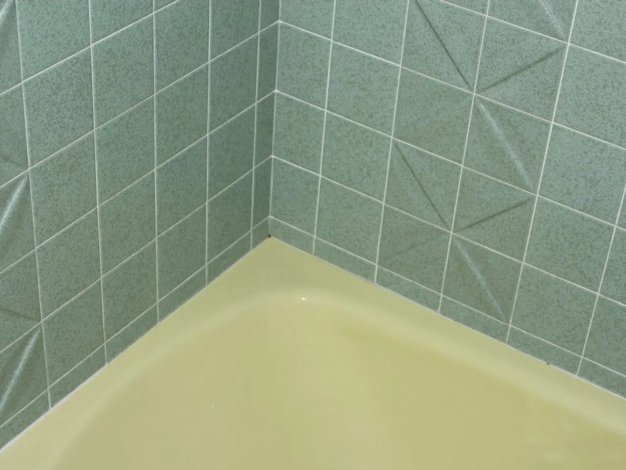 As we can see in the image there is a wall of tiles which is of green colour and below that there...