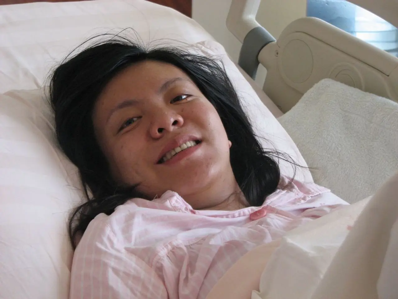 In this image, I can see a person smiling and lying on a bed. On the right side of the image, I can...