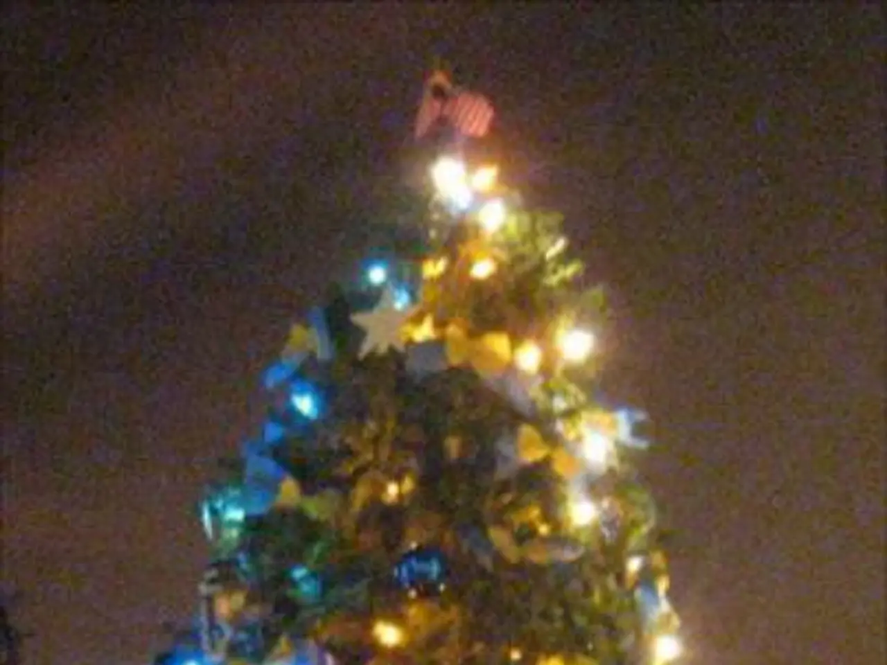 In the image we can see there is a decorated christmas tree and there are statues of people under...