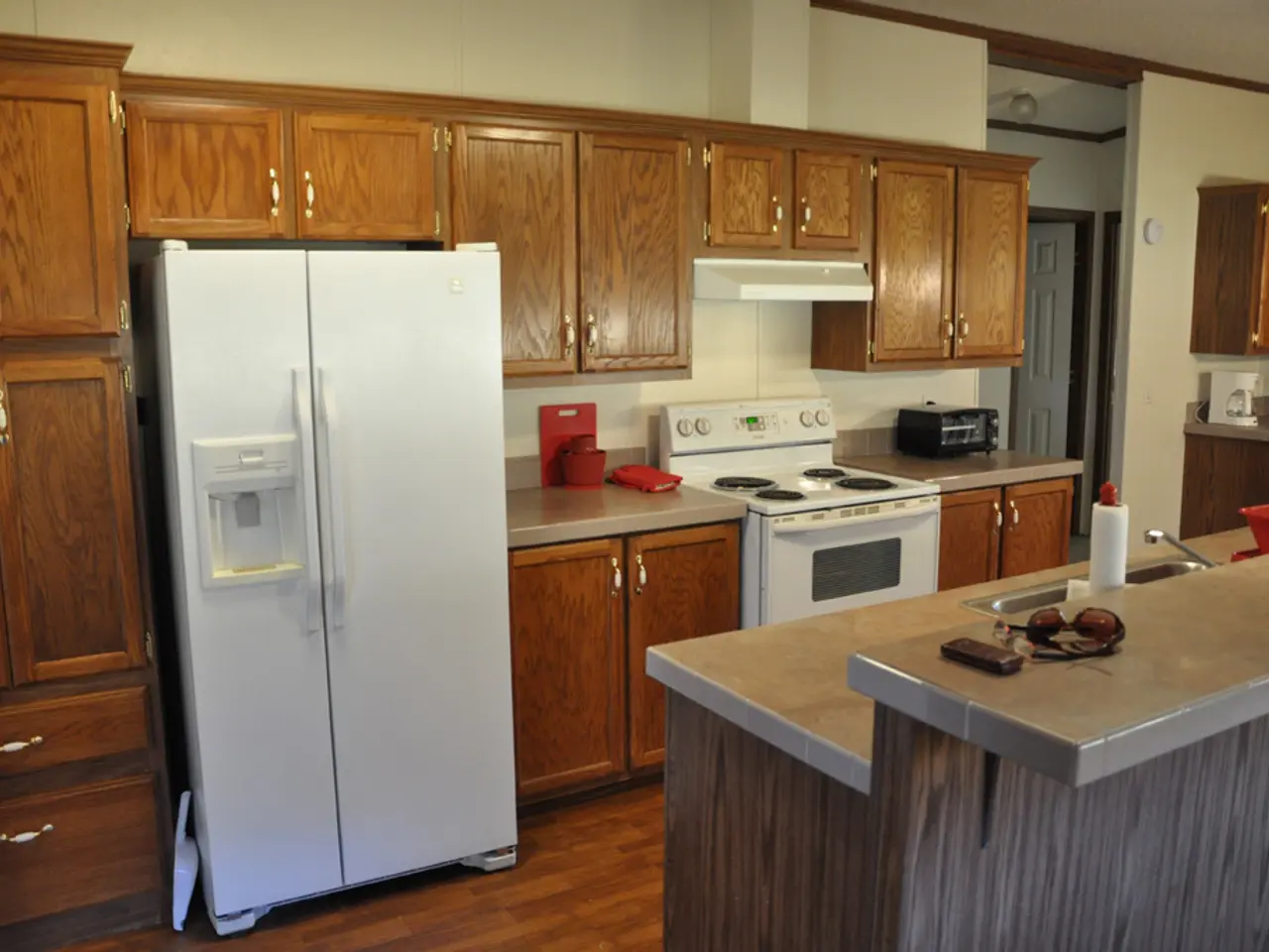 In this image I can see the fridge, stove, oven, sink, tap and few objects on the countertop. I can...