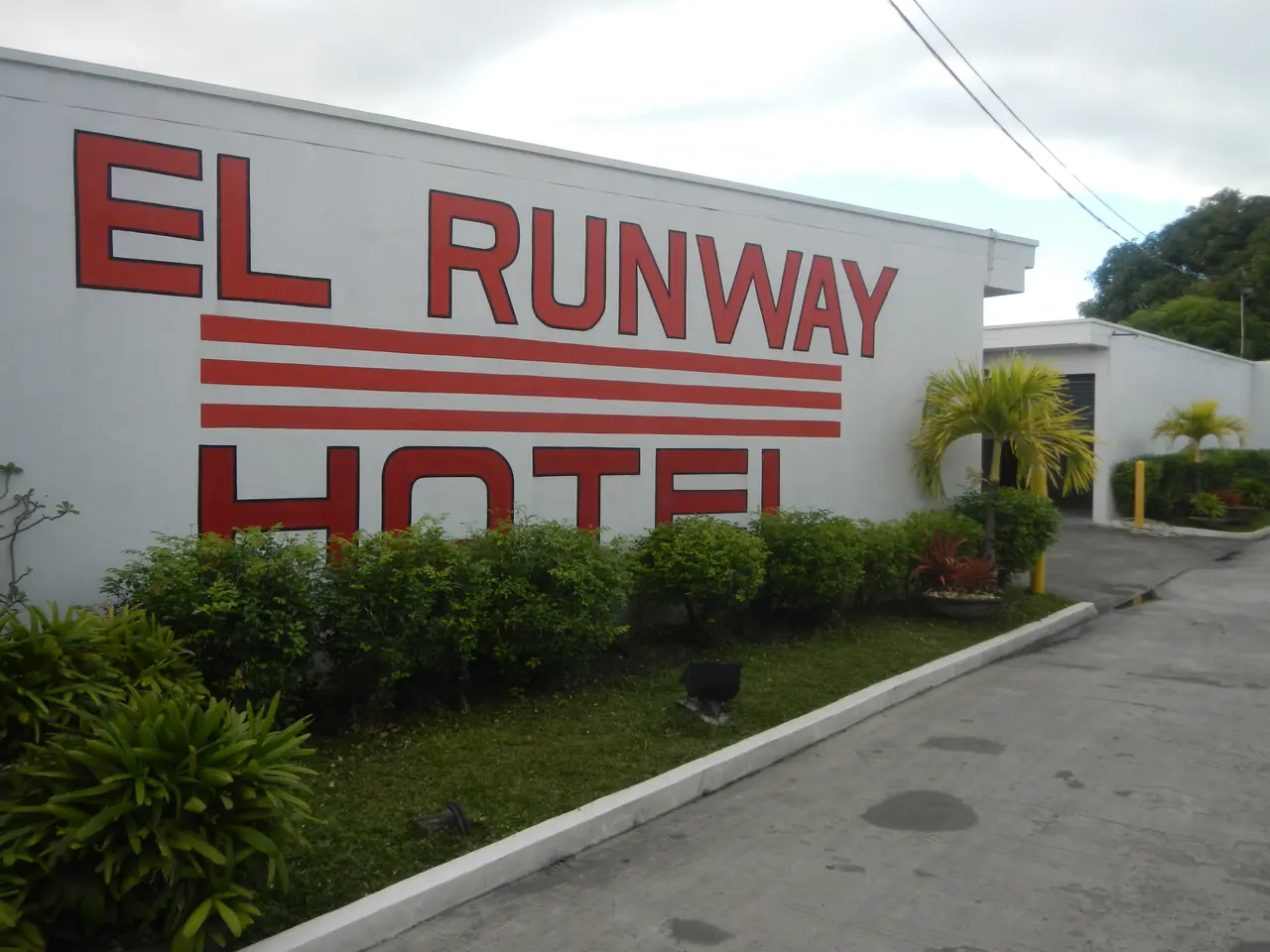 The image shows the El Runway Hotel in Cebu City, Philippines. It features a wall with text on it,...