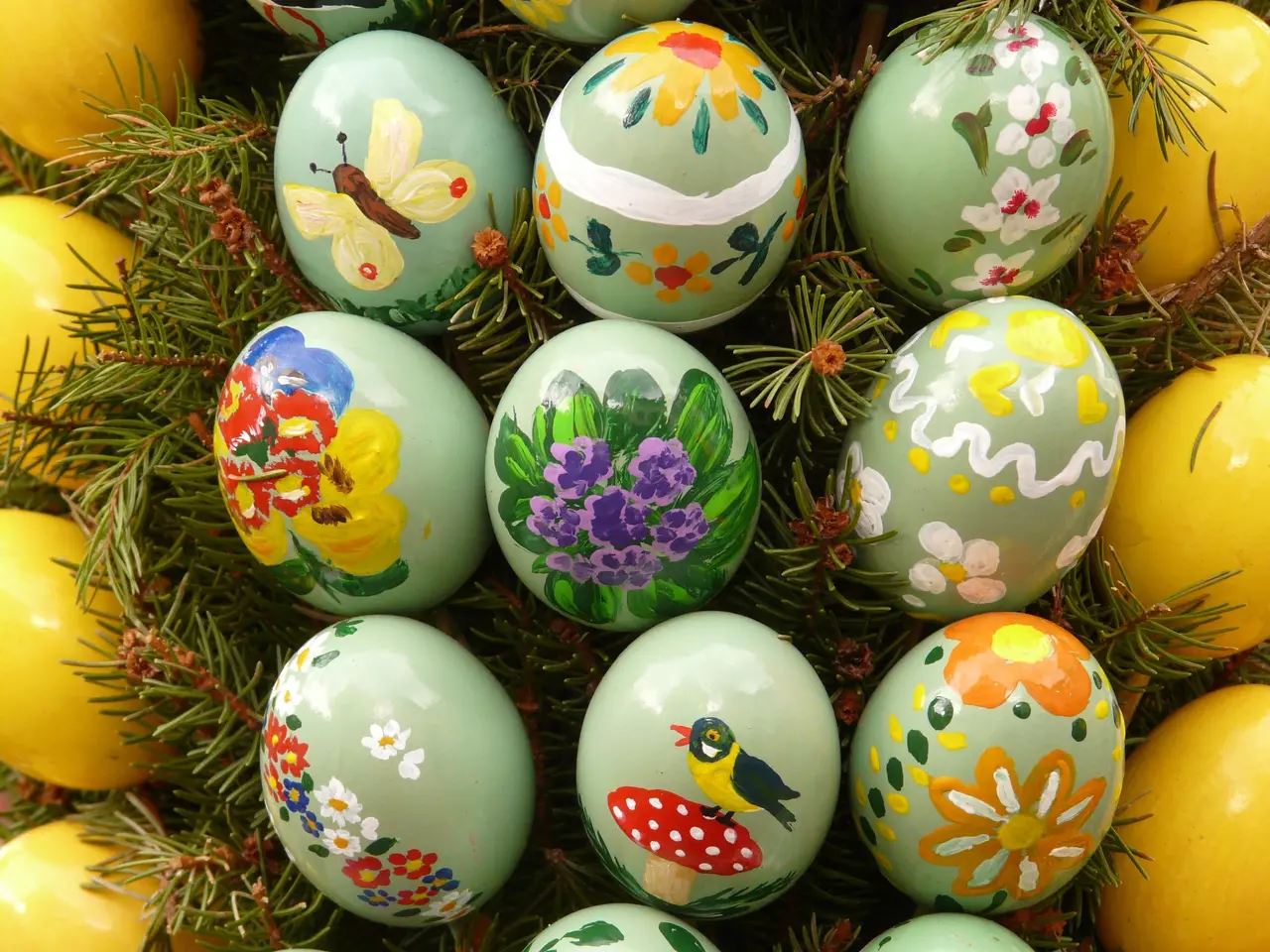 The image shows a bunch of colorful Easter eggs sitting on top of a grass covered field. The eggs...