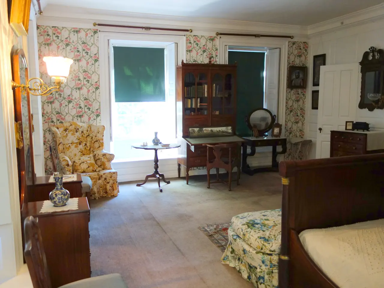 The image shows a bedroom with a bed, dresser, chair, sofa set, side table, table lamp, decors on...