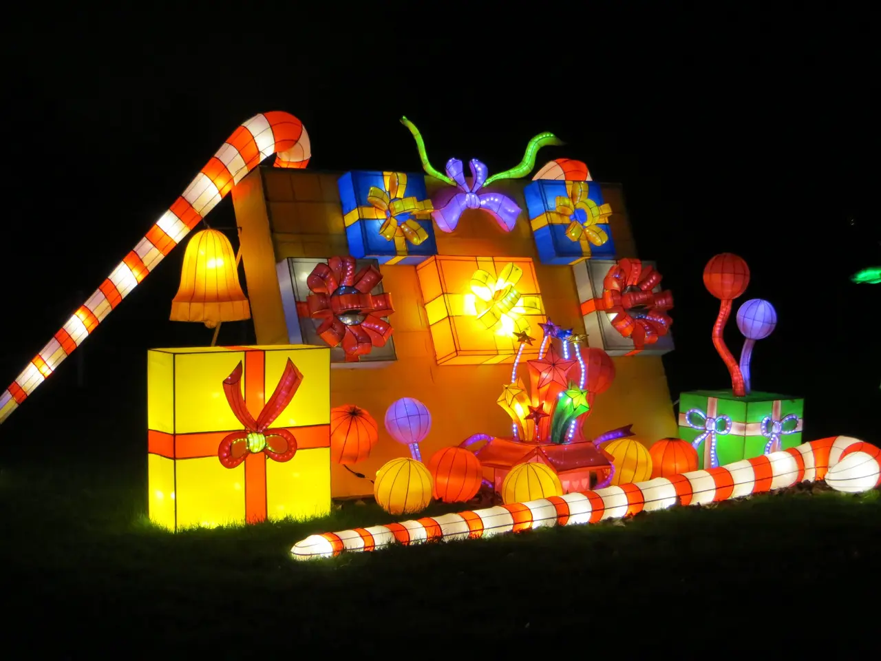 The image shows a house decorated with colorful Christmas lights and presents, illuminated against...