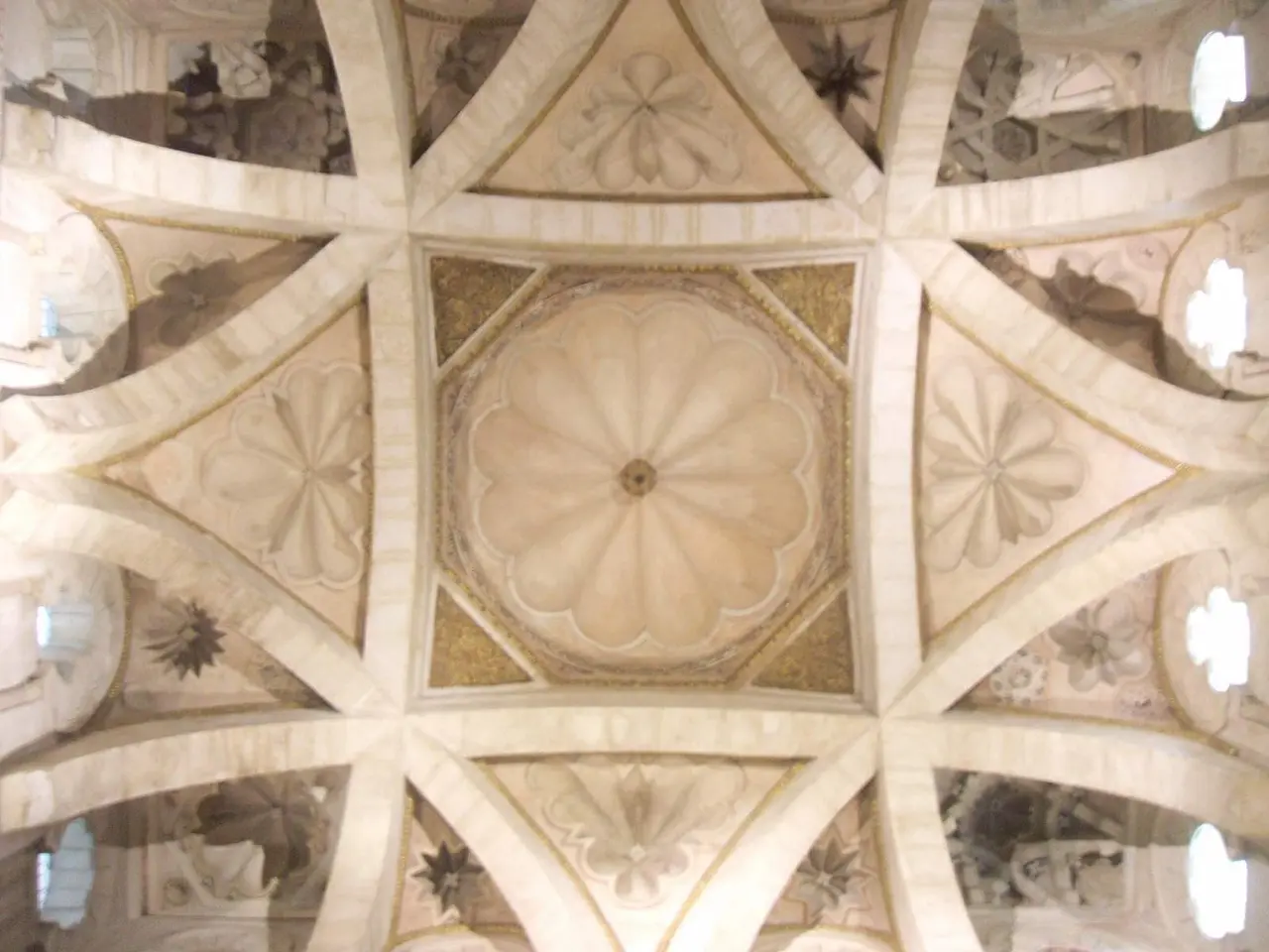 The image shows the interior of a building with a beautiful ceiling featuring intricate designs and...