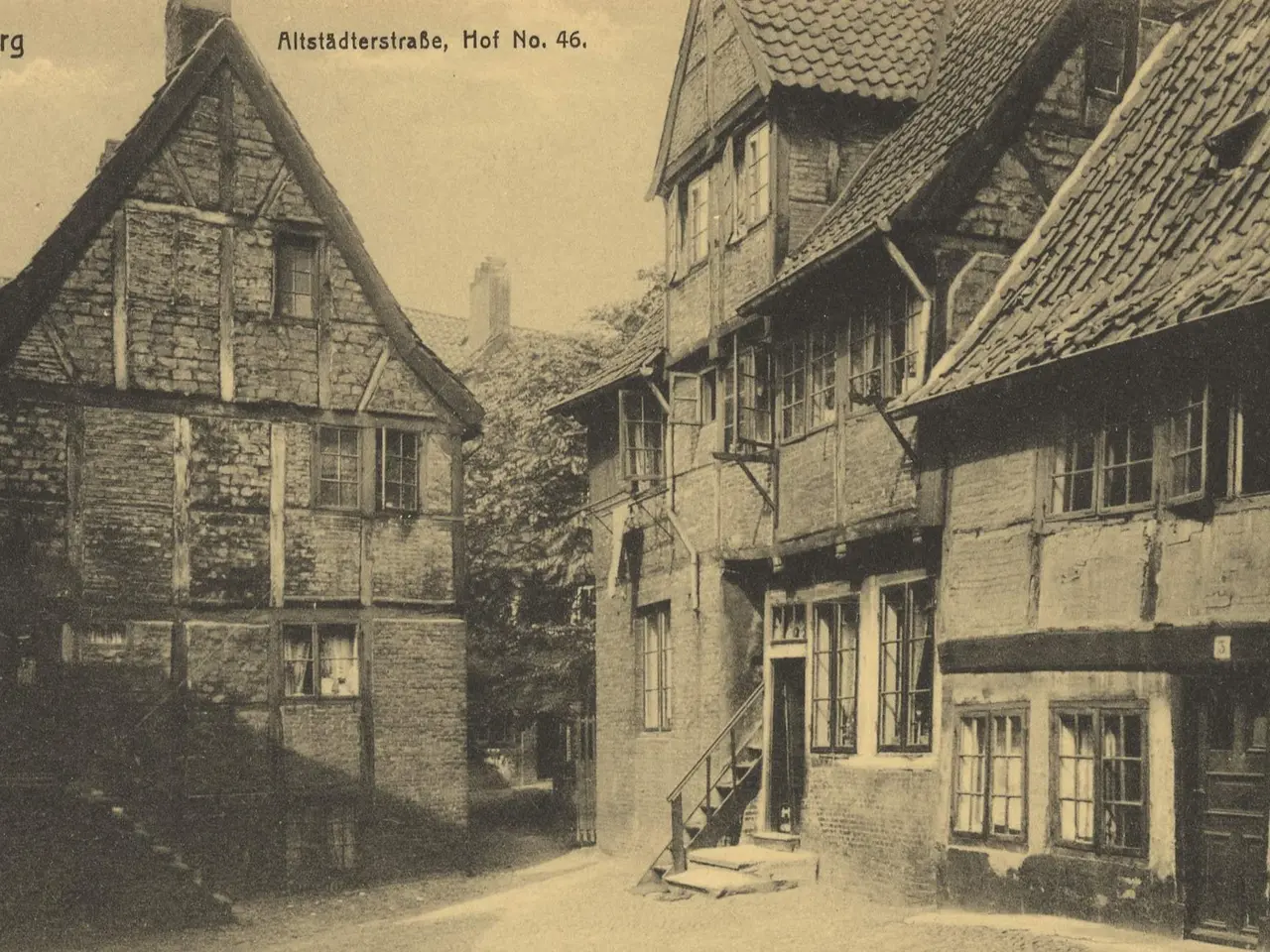 The image shows an old black and white photo of a street in Hamburg, Germany. It features buildings...