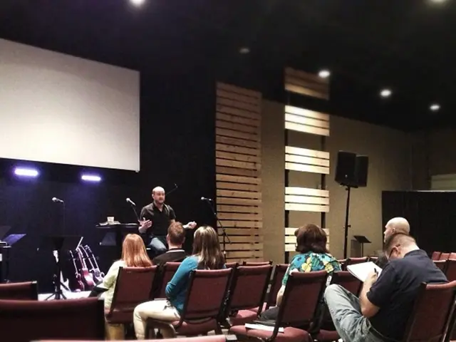 This Picture describe about the in side view of the hall in which some couple of women are sitting...