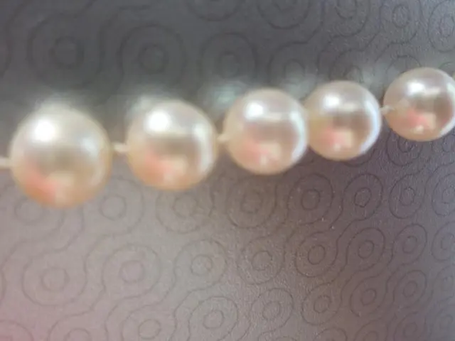 In this image I can see five beads in the front. I can also see grey colour in the background and...
