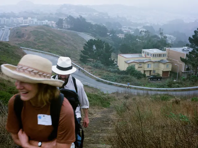 This is a picture taken in the outdoors. There are two person are climbing the mountain. Behind the...