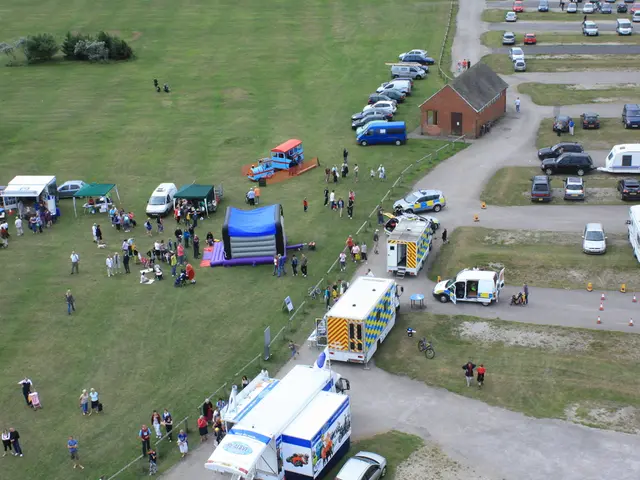This is a top view of an image. In this image there are many vehicles parked and there are a few...