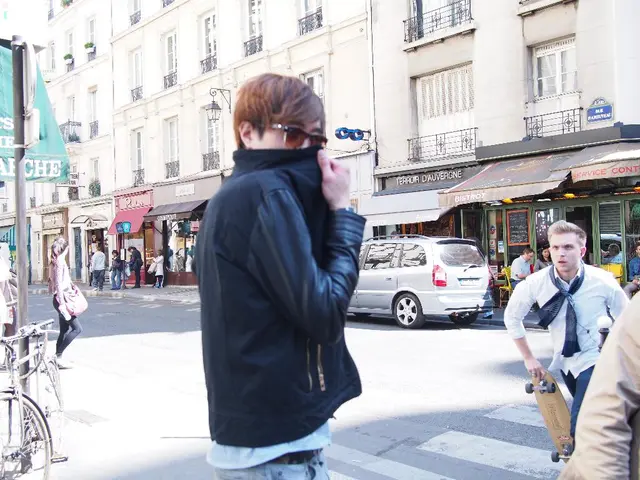 In this image we can see a person wearing specs. On the right side there is a person holding a...