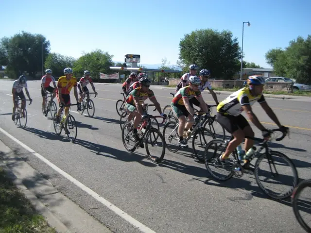 In this image we can see a group of people wearing helmets and goggles riding bicycles on the road,...