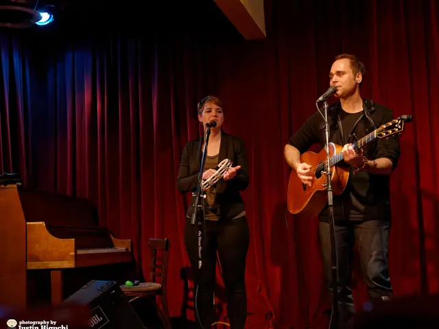 This picture is clicked in a musical concert. On the right of this picture, we see man wearing...