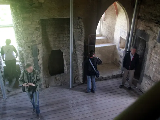 The picture is taken inside a cave where there are people viewing from the windows and few other...