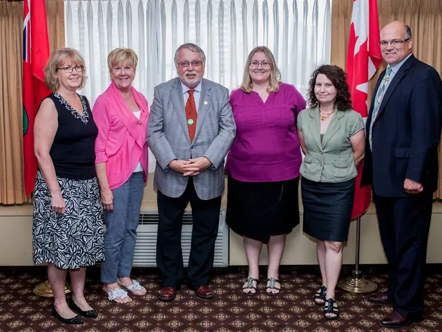 There are six persons in different color dresses, smiling and standing on the floor. In the...