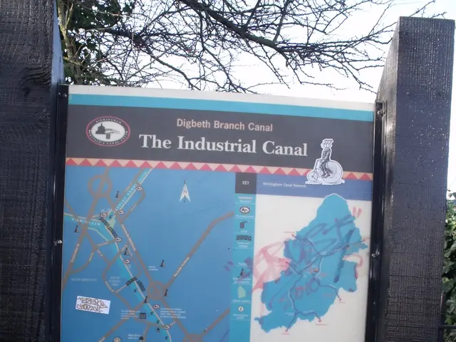 In this image there is a map on the poles, behind that there are so many trees.