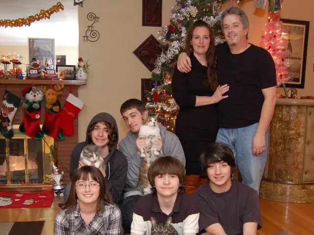 In front of the image there are a few kids sitting on the floor and holding cats in their hands,...