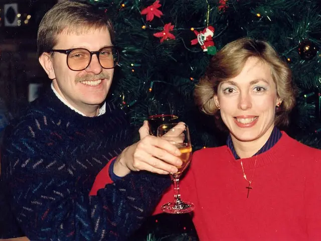 Here we can see a couple holding a glass of wine in their hand and they are smiling. In the...