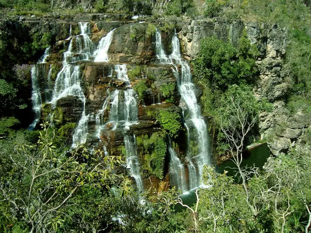 This is the picture of a waterfalls. In this image there is a waterfall and there are trees. At the...