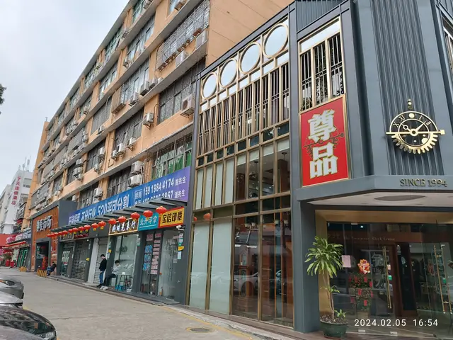The image shows a street with cars parked on the side of it, buildings with windows, air...