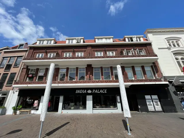 The image shows the India Palace Hotel in Amsterdam, Netherlands. It is a building with windows,...