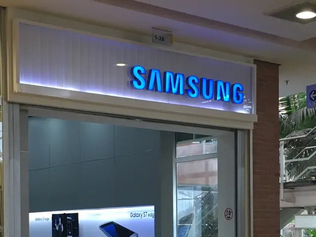The image shows a Samsung store in the middle of a shopping mall, with a name board on the wall, a...
