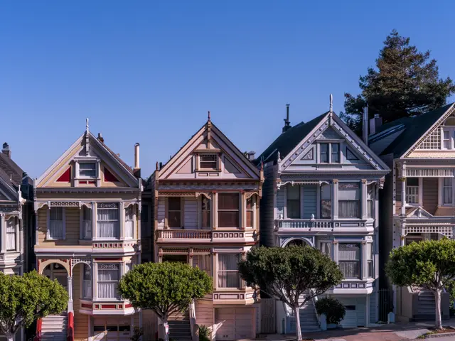 The image shows a row of Victorian-style houses in San Francisco, California, with windows, trees,...