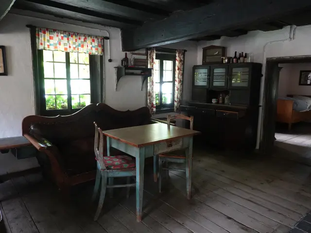 The image shows a living room with a wooden floor, a table and chairs, a sofa, a bench, a cupboard...