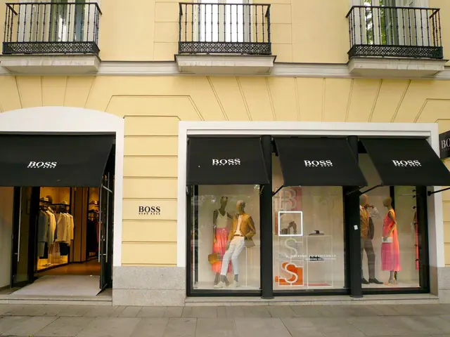 The image shows a building with windows, railings and doors, with mannequins wearing dresses inside...