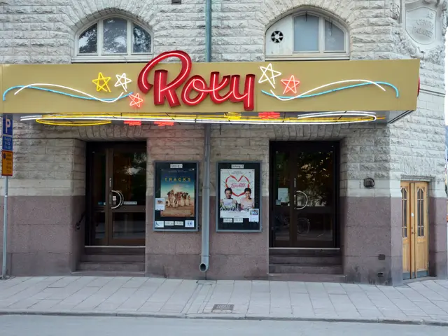 The image shows a building with glass doors and windows, a sign board with text on it, posters on...