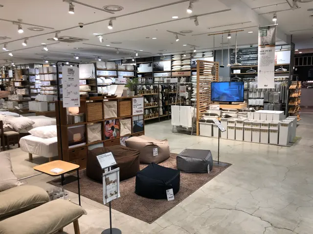 The image shows a large room filled with lots of furniture, including sofas, pillows, cushions,...