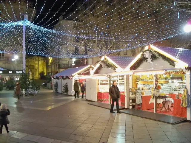 The image shows a bustling Christmas market in the middle of a city at night. We can see a group of...