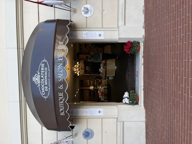 The image shows a building with a sign that reads "Boutique & Salon de Monaco" on the side of it....