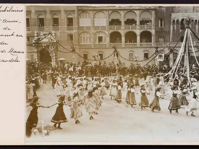 The image shows an old black and white photo of a group of people dancing in front of a building...