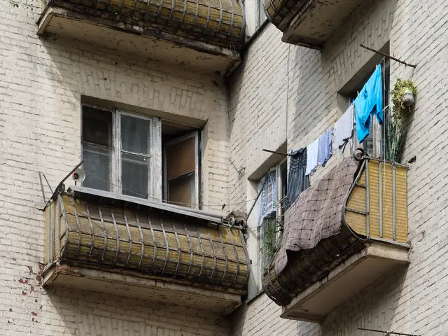 The image shows an apartment building with windows and balconies, and clothes hanging out to dry on...