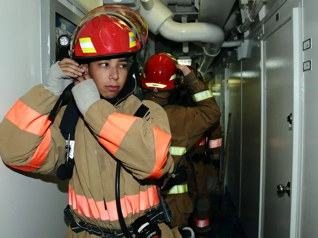 The image shows a group of firefighters in uniform standing next to each other in a room with a...