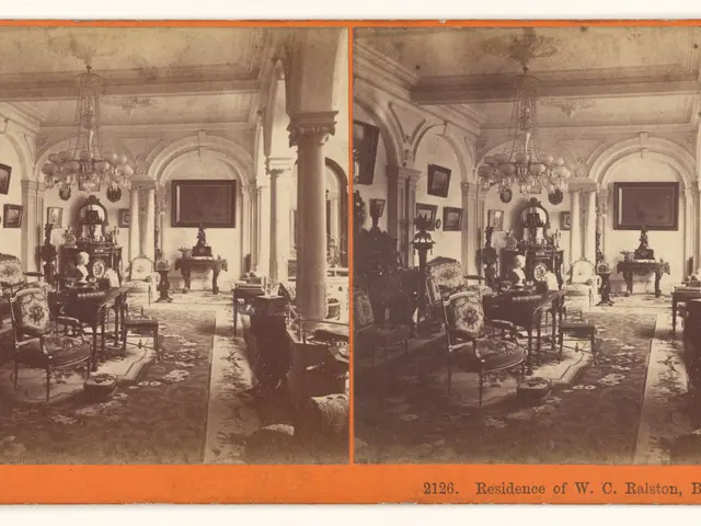 The image shows an old photo of a living room with furniture such as chairs, tables, and...