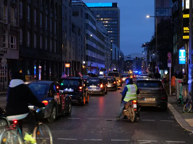 The image shows a city street filled with lots of traffic at night. There are cars, bicycles, and a...