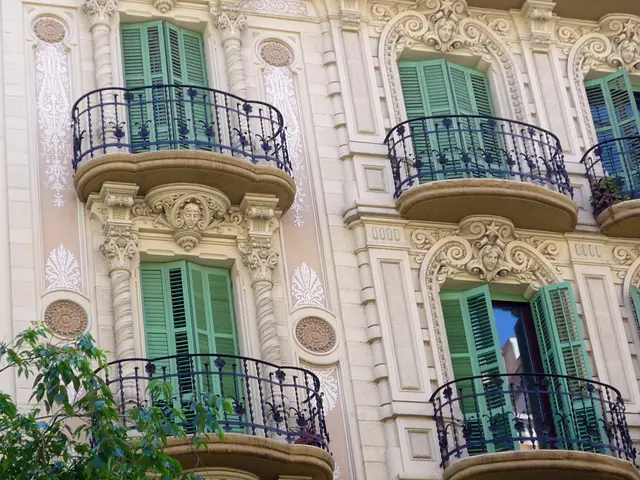 The image shows a building with green shutters and balconies, railings, and a tree on the left...