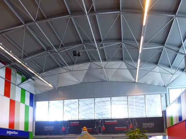 The image shows a large room filled with lots of different types of amusement rides, a plant in a...