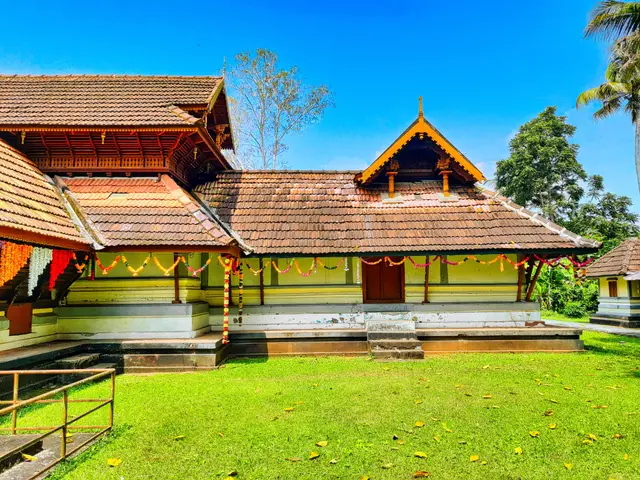 The image shows a house with a roof, steps, railings, grass, dried leaves on the ground, decorative...