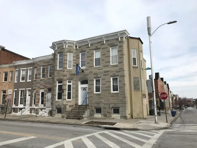 The image shows a row of houses on the corner of a street, with windows, doors, steps with...